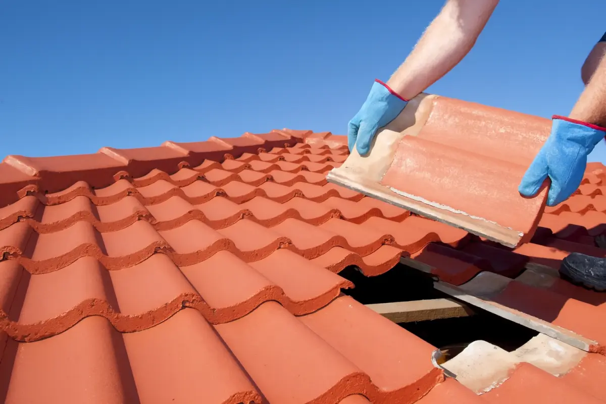Hands installing tile roofing